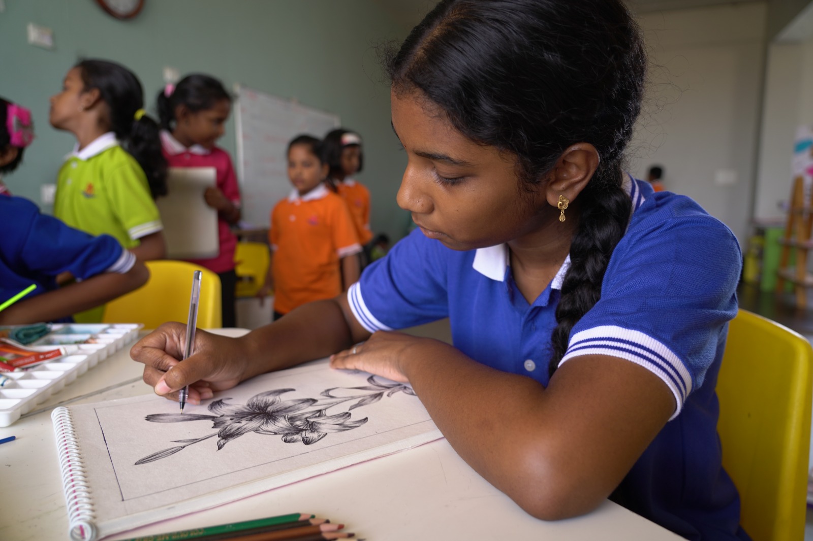 Teacher observing a student sketching during an admission activity