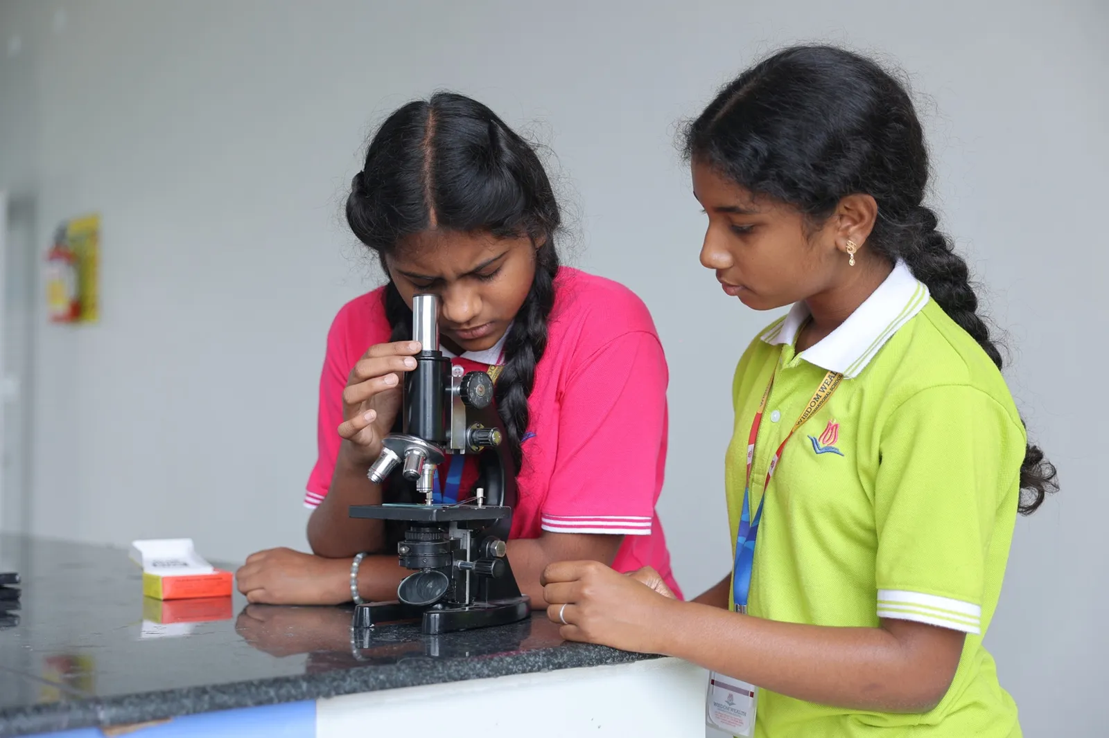 Two students examining a slide under a microscope