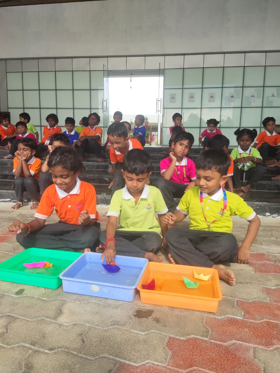 Students floating paper boats they made during a Creative Challenge activity